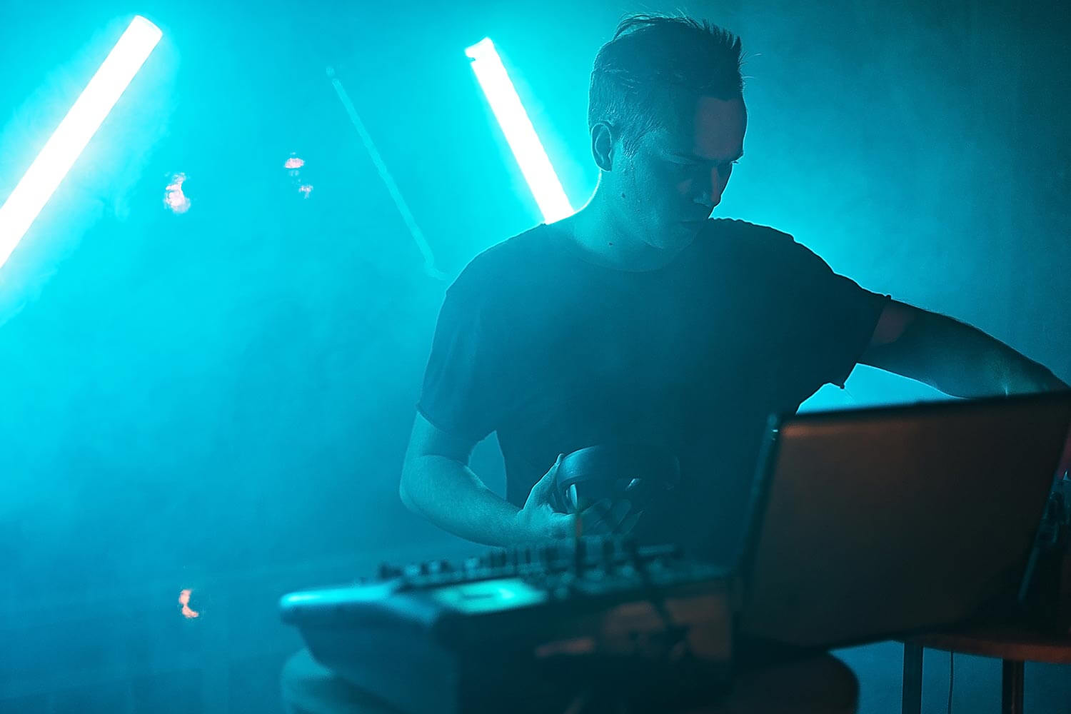 dj holding headphones in a club dj holding headphones in a club