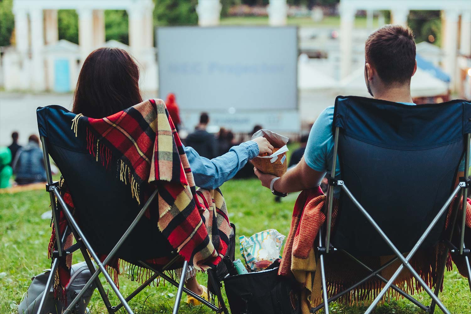 Couple sat in chairs watching an outdoor screening Couple sat in chairs watching an outdoor screening