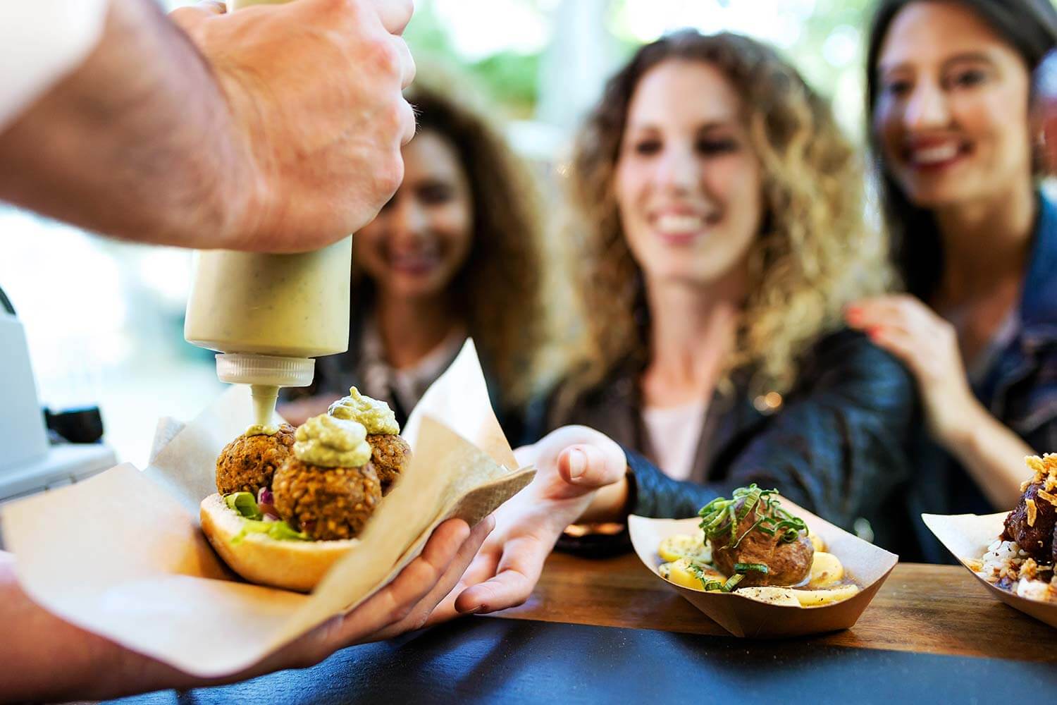 People being served food at a food stall People being served food at a food stall