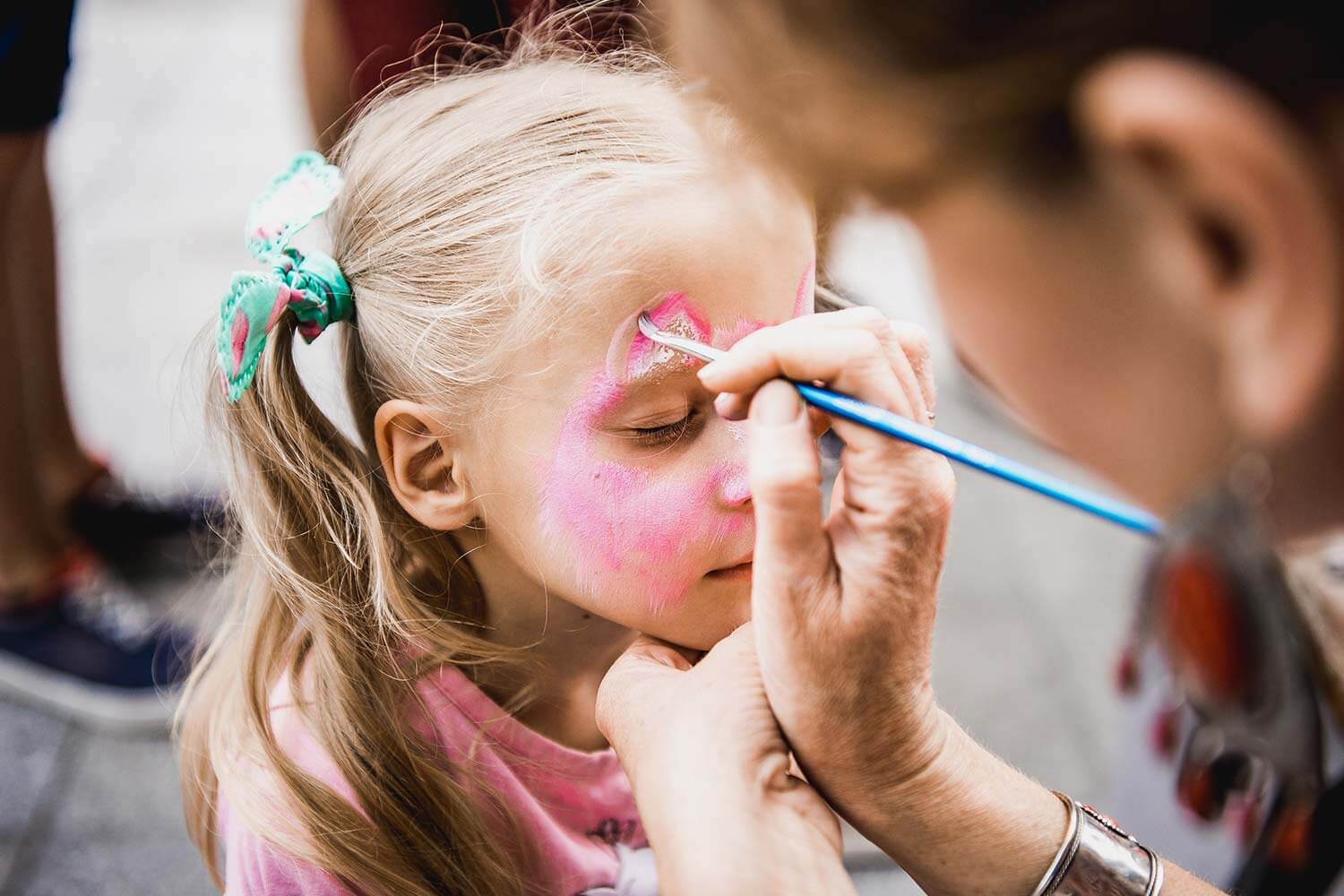 Young girl getting her face painted Young girl getting her face painted